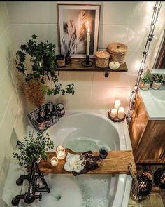 a bathtub with candles and plants in it