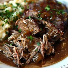 a white plate topped with meat and mashed potatoes