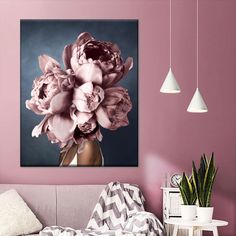 a living room with pink walls and flowers in a vase on the table next to it