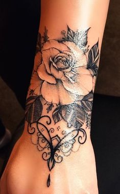 a woman's foot with a rose tattoo on it