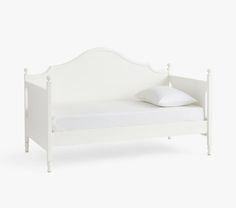 a white daybed with two pillows on the top and bottom, against a white background