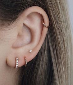 a close up of a person's ear with two different piercings on it