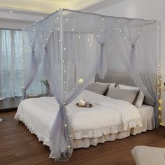 a white bed sitting in a bedroom next to a window with lights on the walls