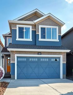 a large blue house with two garages in the front