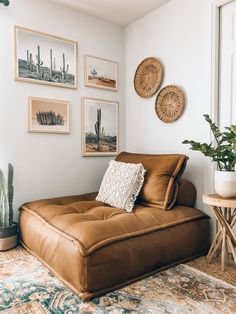 a living room with pictures on the wall and a couch next to a table in front of it