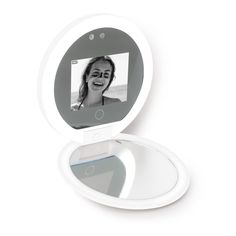 a white compact mirror with a woman's face in the mirror, on a white background