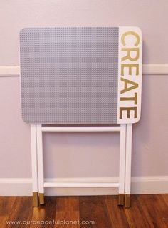 a sign that says create on it next to a wall with wood floors and purple walls