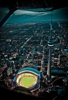 an aerial view of the stadium and surrounding city lights at night, taken from above