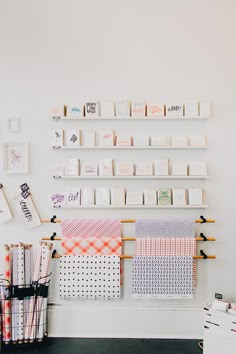 a wall filled with lots of different types of cards and papers on wooden shelves next to each other