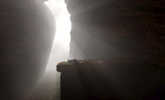 the light is shining through two narrow rocks