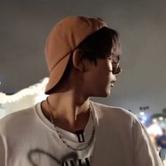 a young man wearing a hat and glasses in front of a large display of lights