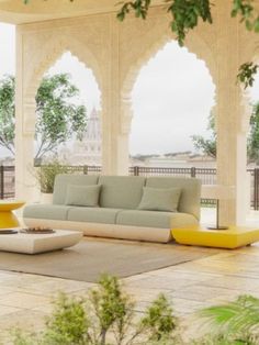 a living room with couches and tables on the floor in front of an archway