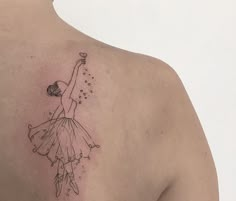 the back of a woman's shoulder with a ballerina tattoo design on it