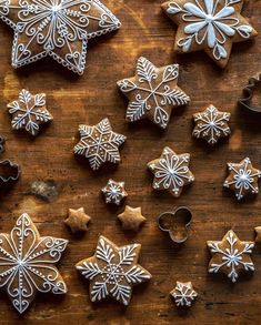 christmas cookies and cookie cutters on a wooden table with snowflakes in the shape of stars