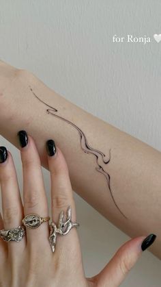 a woman's arm with tattoos on it and her hand holding onto the wrist