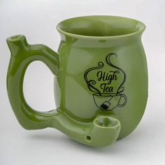 a green coffee mug with the words high tea on it's side and a handle