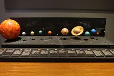 the solar system is on display in front of a wooden table with an earth model