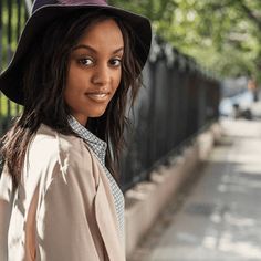 a woman wearing a purple hat and trench coat