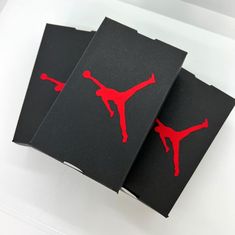 three black and red cards with the logo of a person doing a trick on them