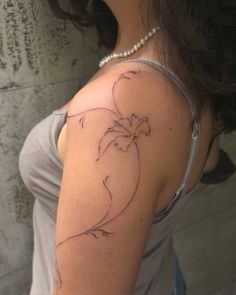 a woman's arm with a tattoo on it that has an outline of a flower