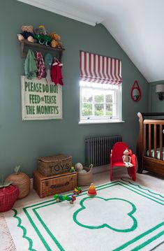 a child's room with green and white carpet, red chair, teddy bear