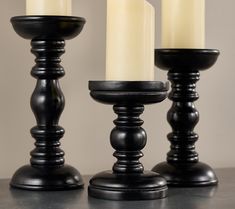 three candles sitting on top of a table next to each other with one lit candle in the middle