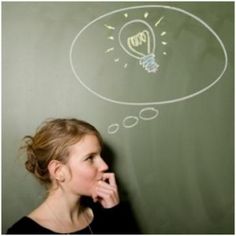 a woman is standing in front of a chalkboard with an idea written on it