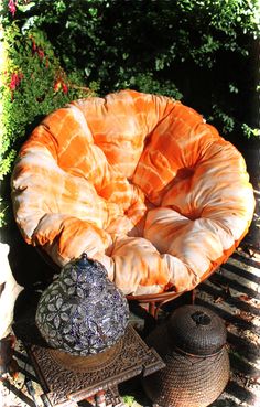 an orange chair sitting on top of a grill next to a hat and other items