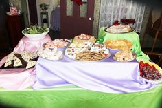 a table filled with lots of food on top of a green cloth covered tablecloth