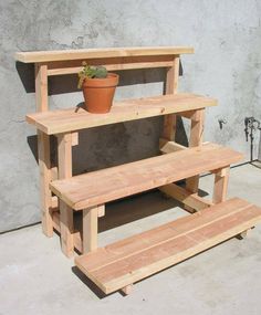 a potted plant sitting on top of a wooden shelf next to a cement wall