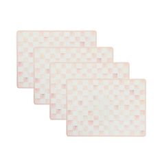 three white place mats with pink squares on them