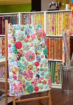 a chair sitting in front of a book shelf filled with books and paper work on it