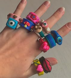 a person's hand with rings on it and some toys in the middle of their fingers