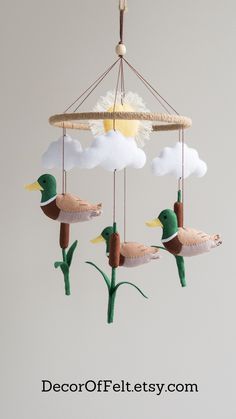 a mobile with ducks and clouds hanging from it