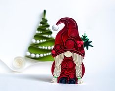 an origami santa clause standing next to a christmas tree