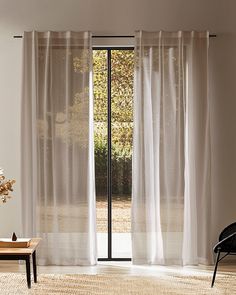 a living room with an open door and white curtains