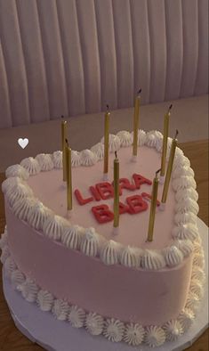 a heart shaped birthday cake with candles on it