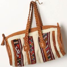 En Shalla For Anthropologie Woven Carpet Satchel Leather And Shearling Striped Textile Braided And Stitched Leather Detail Double Braided Handles Zip Top Closure Shearling Lined Interior Zipper And Slip Pocket Made In Morocco Width:15" Height:11" Depth:5.5" Drop: 5.5" Cream Woven Satchel Bag, Cream Woven Leather Bag, Elegant Market Bags With Braided Handles, Cream Woven Satchel Shoulder Bag, Cream Handwoven Shoulder Bag For Travel, Chic Cream Handwoven Bag, Beige Woven Leather Bags, Artisan Beige Travel Bag, Bohemian Beige Shoulder Bag With Handles