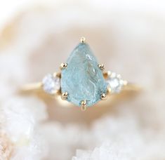 a blue diamond ring sitting on top of some crystals