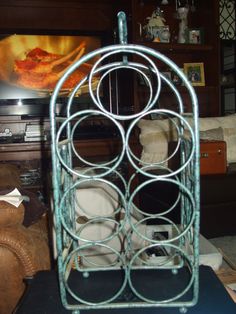 a metal rack with several circles on it in front of a couch and coffee table