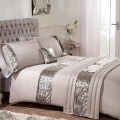 a bed with silver sequins and pillows on it