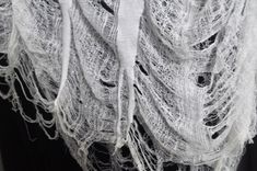 a white shawl draped over a black shirt