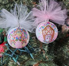 three ornaments are hanging from a christmas tree with pink and white bows on them,