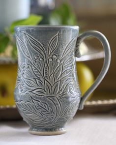 a silver coffee cup sitting on top of a table