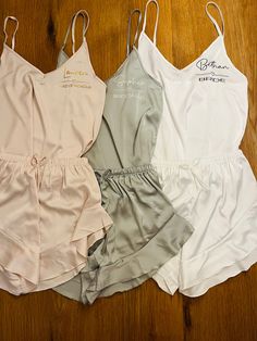 three women's bras are lined up on the floor, one in white and one in grey