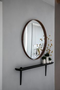 a mirror and some vases on a shelf