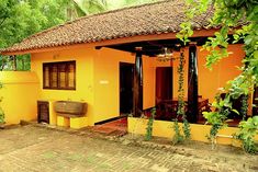 a yellow house with a bench in front of it