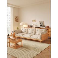 a living room filled with furniture and a white rug on top of a hard wood floor