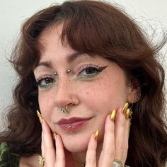 a close up of a person with some rings on their fingers and wearing gold jewelry