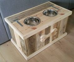 a dog bowl stand made out of pallet wood with two bowls on the top